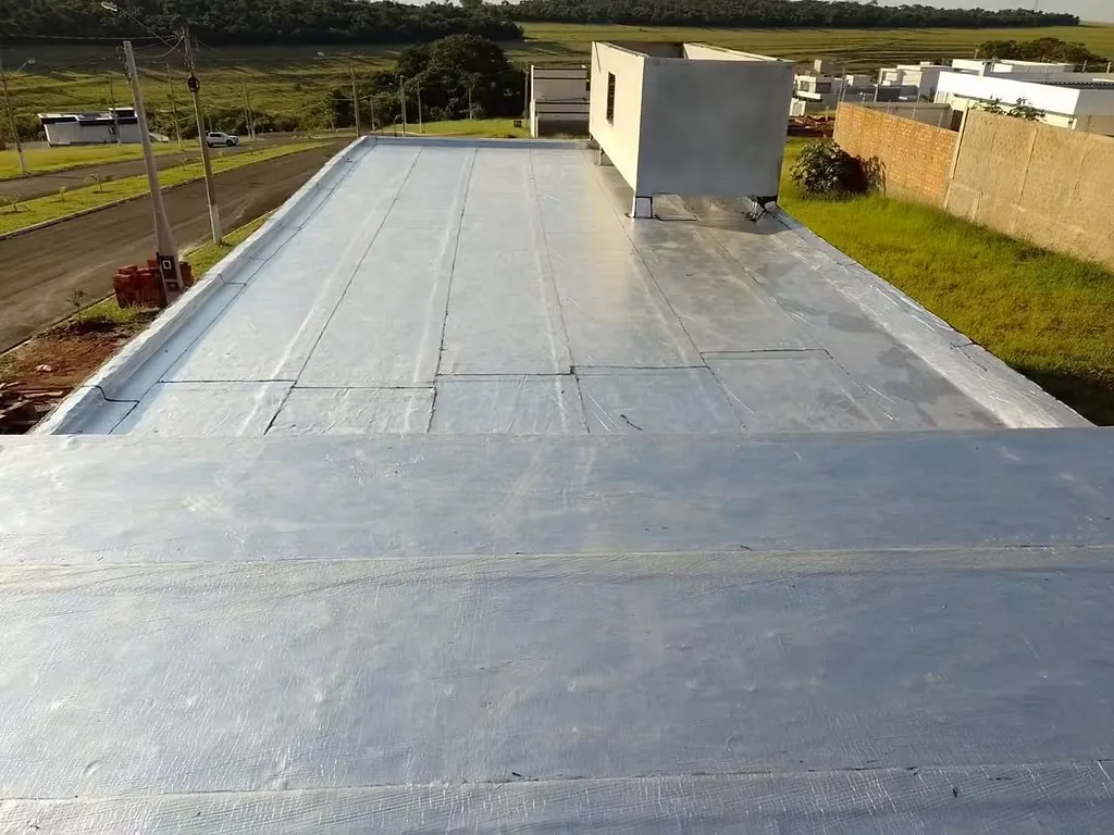 Laje com manta aluminizada ao lado de um campo